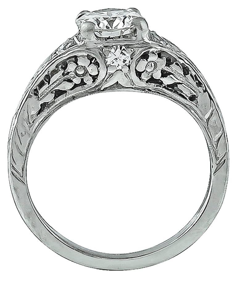 This platinum ring inspired from the Edwardian era, centers a sparkling GIA certified round brilliant cut diamond that weighs 0.77ct. graded I color with VVS2 clarity. Accentuating the center stone are high quality round cut diamond accents.The ring