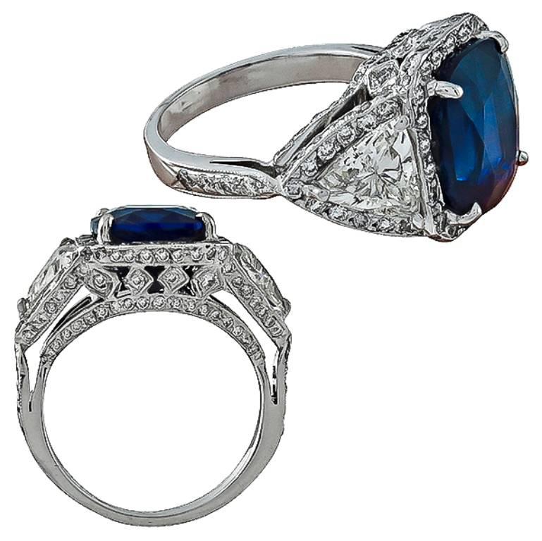 This stunning 18k white gold ring is centered with a gorgeous GRL certified cushion cut Ceylon sapphire that weighs 8.18ct. The sapphire is flanked by two sparkling GIA certified trilliant cut diamonds that weigh 1.00ct and 0.99ct. The color of the