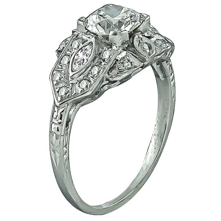 Made of platinum, this ring centers a sparkling GIA certified round cut diamond that weighs 0.70ct. and is graded I color with VS2 clarity. Accentuating the center stone are high quality dazzling round and marquise cut diamond accents. The ring is