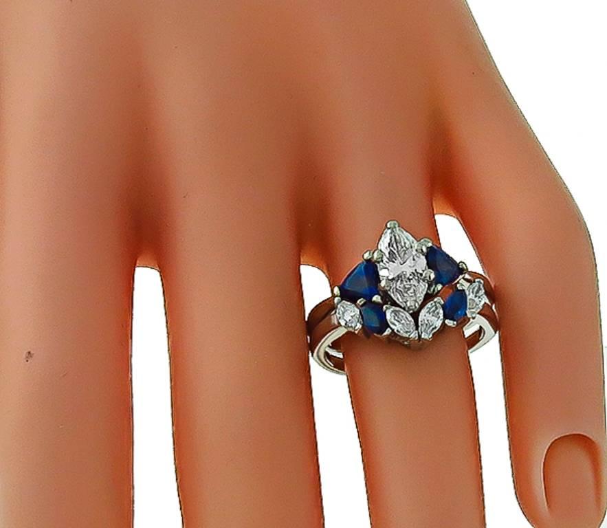 Made of 14k white gold, this ring centers a sparkling GIA certified marquise cut diamond that weighs 1.08ct. graded G color with SI1 clarity. The center stone is accentuated by pear & marquise cut sapphire and high quality marquise cut diamonds. The