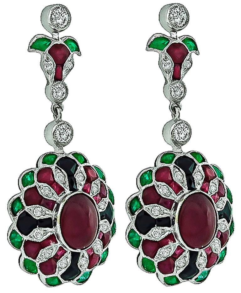 Made of 18k white gold, these earrings are centered with cabochon cut rubies weighing approximately 5.65ct. Accentuating the rubies are round cut diamonds that weigh approximately 0.85ct and are graded H color with VS clarity. The earrings also