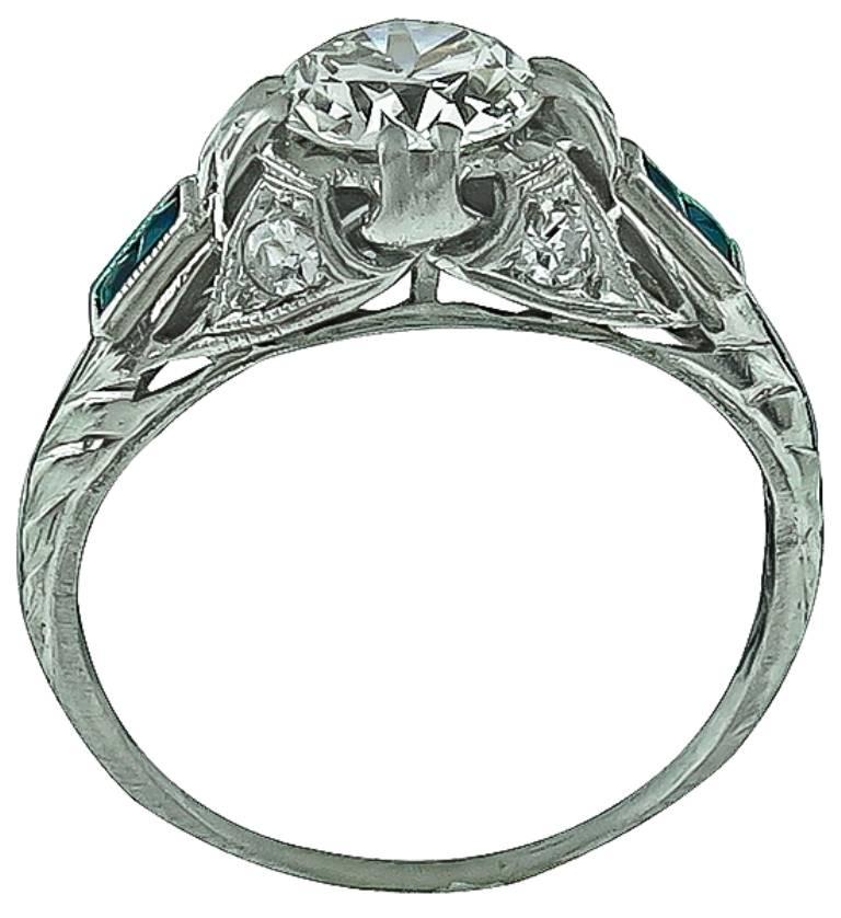 This stunning platinum engagement ring from the Art Deco era, centers a sparkling EGL certified round cut diamond that weighs 1.02ct. graded H-I color with VS2 clarity. Accentuating the center stone are blue sapphires and high quality round cut
