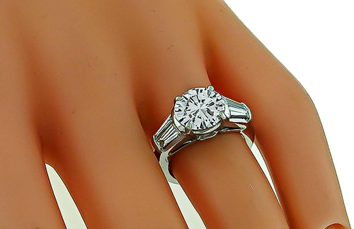This stunning  platinum engagement ring is centered with a sparkling GIA certified round brilliant cut diamond that weighs 2.36ct. graded I color with SI2 clarity. The center diamond is flanked by dazzling baguette cut diamonds weighing