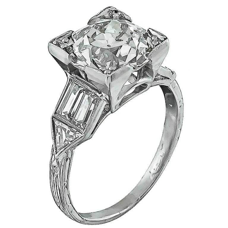 This stunning platinum engagement ring from the Art Deco era,  is centered with a sparkling EGL certified old European cut diamond that weighs 2.65ct. graded J-K color with VS2 clarity. Accentuating the center stone are high quality baguette and