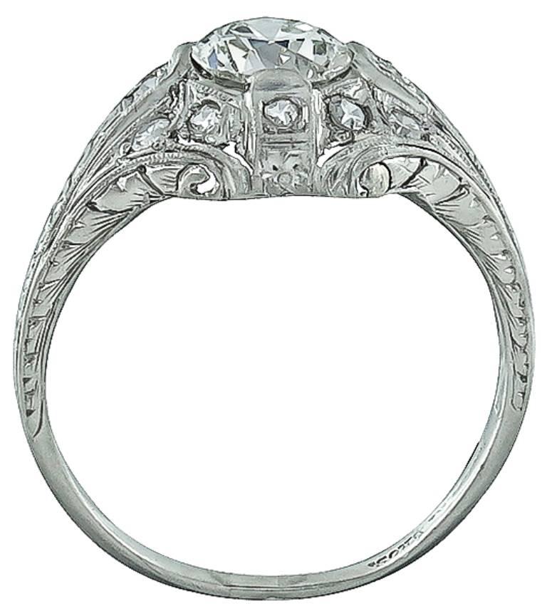 Handcrafted from the Art Deco era, this ring is centered with a sparkling GIA certified circular brilliant cut diamond that weighs 0.93ct. graded J color with VS2 clarity. The center diamond is accentuated by dazzling round cut diamond accents. The