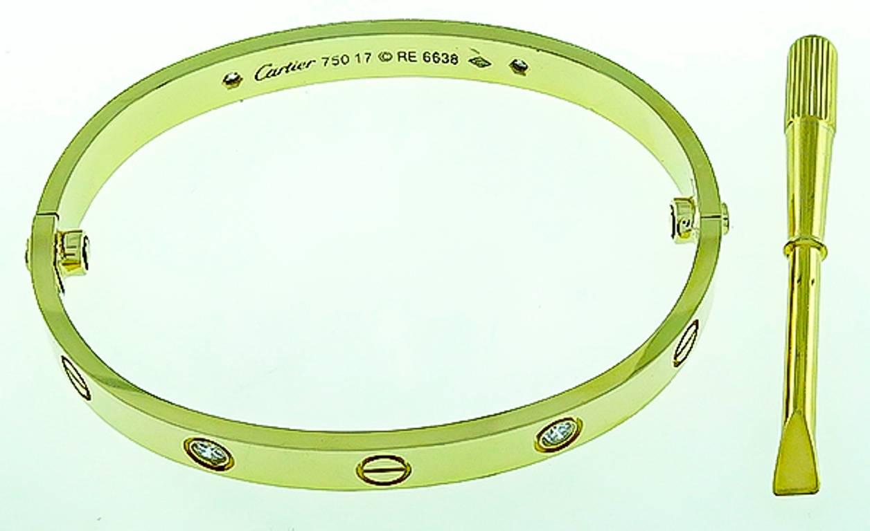 This classic 18k yellow gold Cartier diamond love bangle is set with 4 sparkling E/VS round cut diamonds with an approximate weight of 0.40ct.
The bangle is Cartier size 17, 6mm in width and weighs 36.2 grams. It is signed Cartier 750 17 with