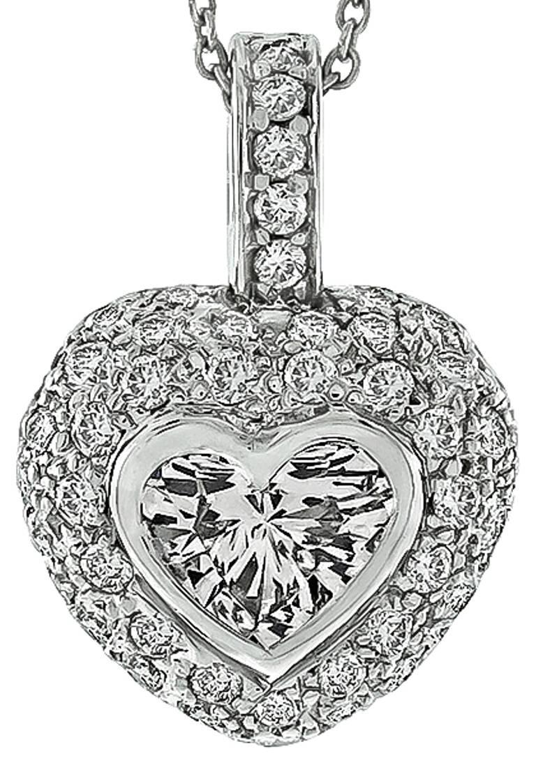 Made of 18k white gold, this stunning pendant is centered with a sparkling GIA certified heart shape diamond that weighs 1.06ct. and is graded K color with SI1 clarity. Accentuating the center stone are dazzling round cut diamonds that weigh