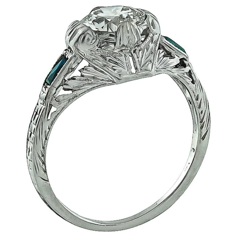 Made of 18k white gold, this amazing ring centers a sparkling old European cut diamond that weighs approximately 0.90ct. graded L-M color with VS1 clarity. The center diamond is flanked by lovely sapphire accents. The top of the ring measures 9mm by