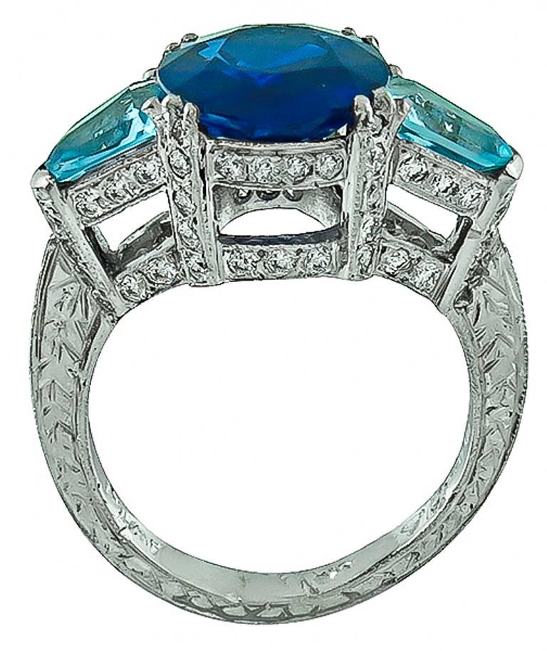 Made of platinum this ring centers a natural oval cut Ceylon sapphire that weighs 5.42ct. The sapphire is flanked by shield cut aquamarines weighing approx 1.50ct. and high quality round cut diamonds weighing approx 1.50ct graded H color with VS