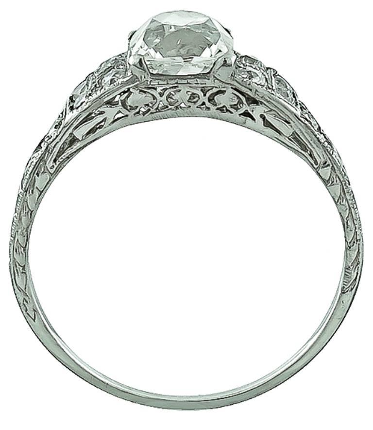 This amazing platinum engagement ring centers a unique GIA certified  modified square brilliant cut diamond that weighs 1.30ct. graded J color with VS2 clarity. Accentuating the center stone are high quality round cut diamonds that weigh