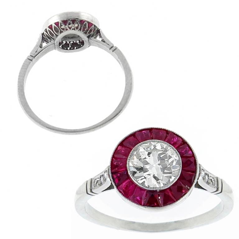 This gorgeous platinum engagement ring centers a sparkling GIA certified old European brilliant cut diamond that weighs 0.59ct. graded H color with VS2 clarity. Accentuating the center stone are high quality calibre cut rubies weighing approximately