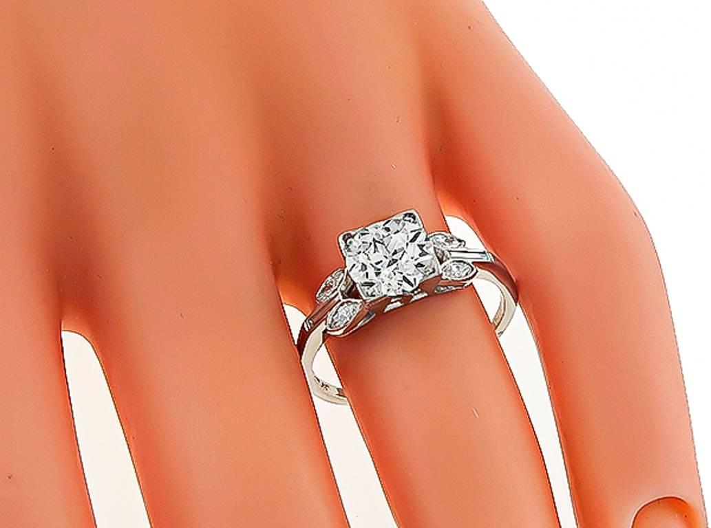 This stunning platinum engagement ring from the Art Deco era, is centered with a sparkling GIA certified old European cut diamond that weighs 1.56ct. graded I color with SI1 clarity. Accentuating the center stone are dazzling marquise and baguette