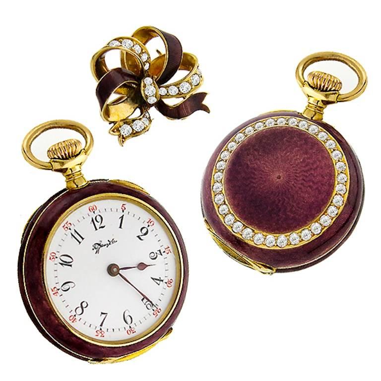 This gorgeous Victorian 18k yellow gold watch/pendant by Tiffany & Co, features black 1-12 hour numerals and red minutes numerals. The case of the watch has purple enamel inlay and sparkling old mine cut diamonds that weighs approximately 3.00ct.