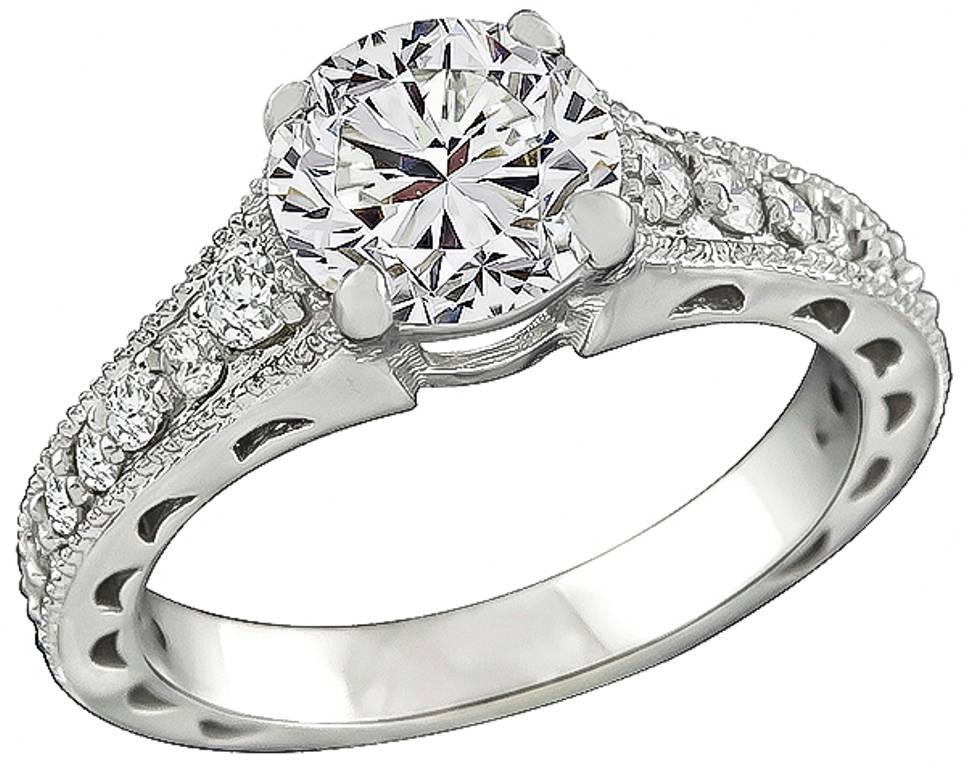 The engagement ring centers a sparkling GIA certified round brilliant cut diamond that weighs 1.57ct. graded J color with SI2 clarity. The set features high quality dazzling round cut diamonds that weigh approximately 1.25ct. graded G-H color with