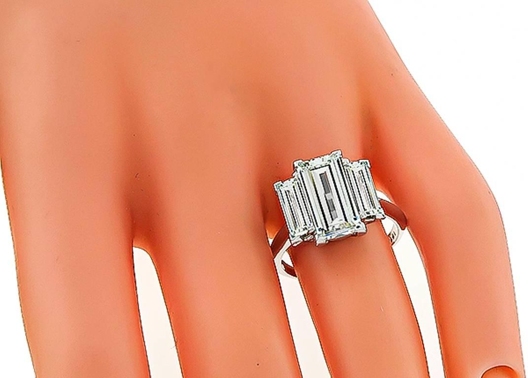 This stunning platinum engagement ring is centered with a sparkling GIA certified emerald cut diamond that weighs 2.49ct. graded I color with VS2 clarity. The center diamond is flanked by two dazzling emerald cut diamonds that weigh approximately
