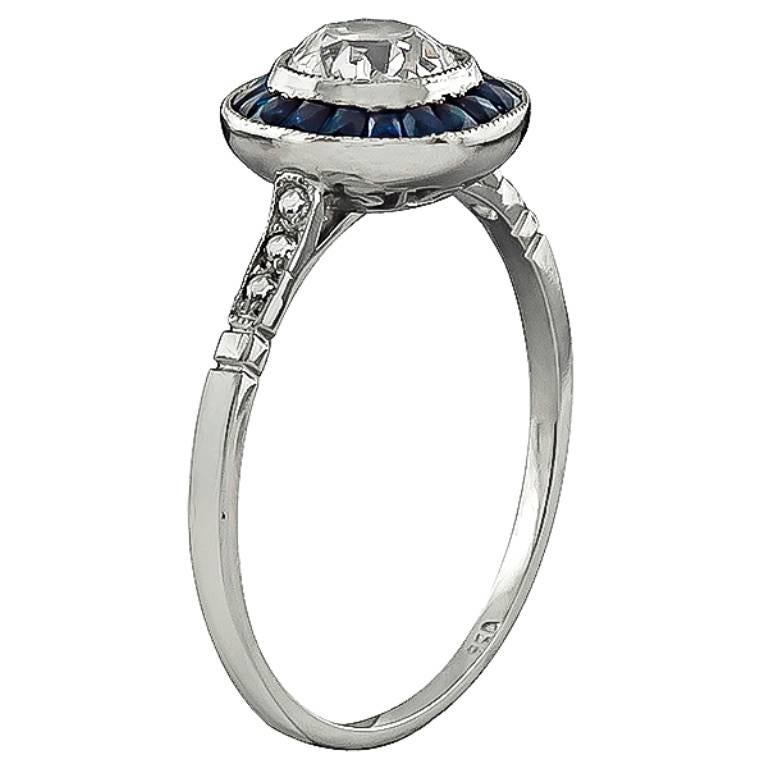 This amazing platinum engagement ring is centered with a sparkling cushion cut diamond that weighs 0.67ct. graded I-J color with VS clarity. The center diamond is accentuated by faceted calibre cut sapphire accents.
The ring is size 7 1/4, and can