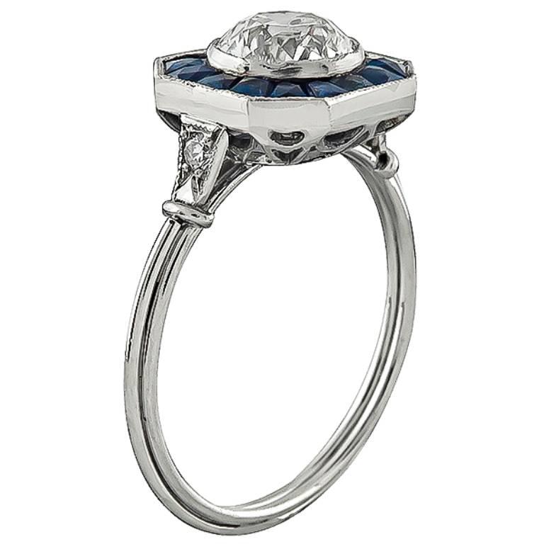 This amazing platinum ring is centered with a sparkling GIA certified old mine cut diamond that weighs 1.09ct. graded K color with VS1 clarity. The center stone  is accentuated by faceted calibre cut sapphire accents.
The ring is size 6 3/4, and