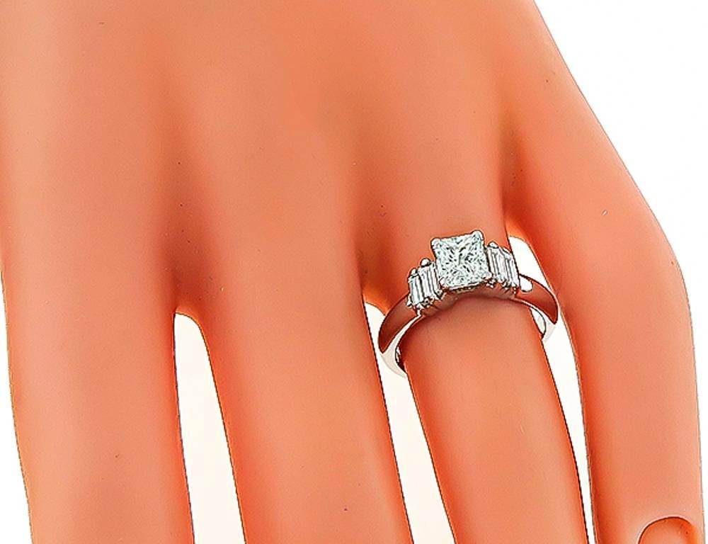 This magnificent 14k white gold ring is centered with a sparkling GIA certified princess cut diamond that weighs 0.71ct. graded I color with VS2 clarity. The center stone is flanked by dazzling baguette cut diamonds that weigh approximately 0.20ct.