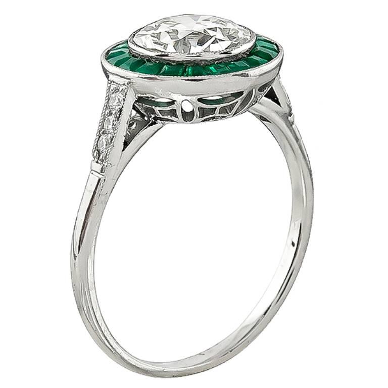 This amazing platinum engagement ring is centered with a sparkling old European cut diamond that weighs 1.57ct. graded K color with VS1 clarity. The center diamond is accentuated by emerald and diamond accents. It is currently size 7 1/4, and can