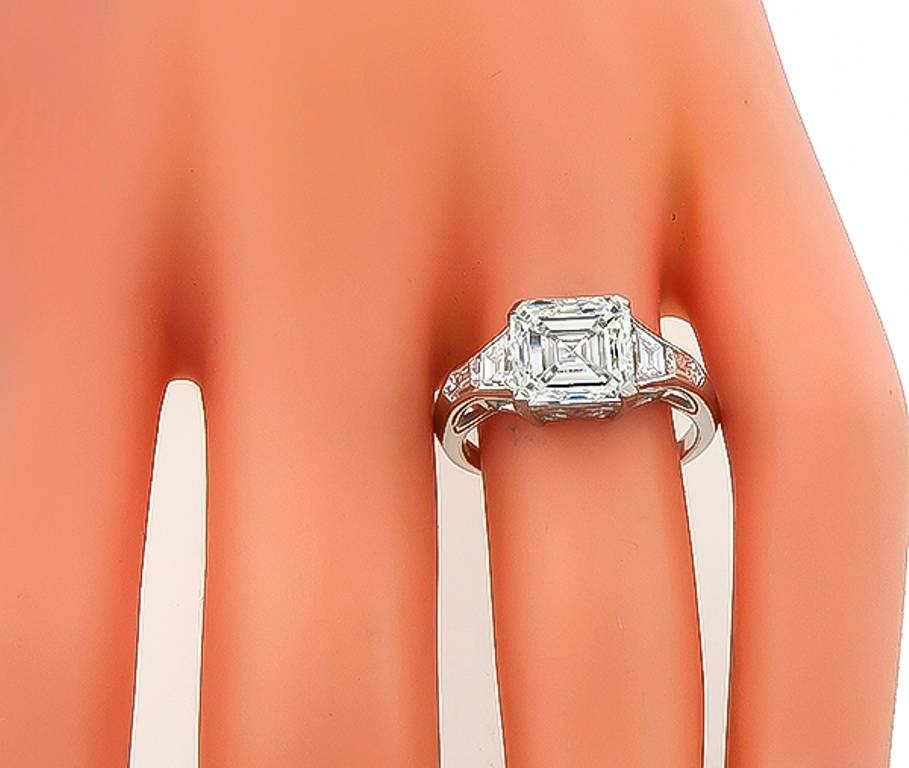 This elegant platinum ring is centered with a sparkling GIA certified square emerald cut diamond that weighs 3.01ct. graded J color with VS1 clarity. The center stone is flanked by high quality shield and trapezoid cut diamonds that weigh
