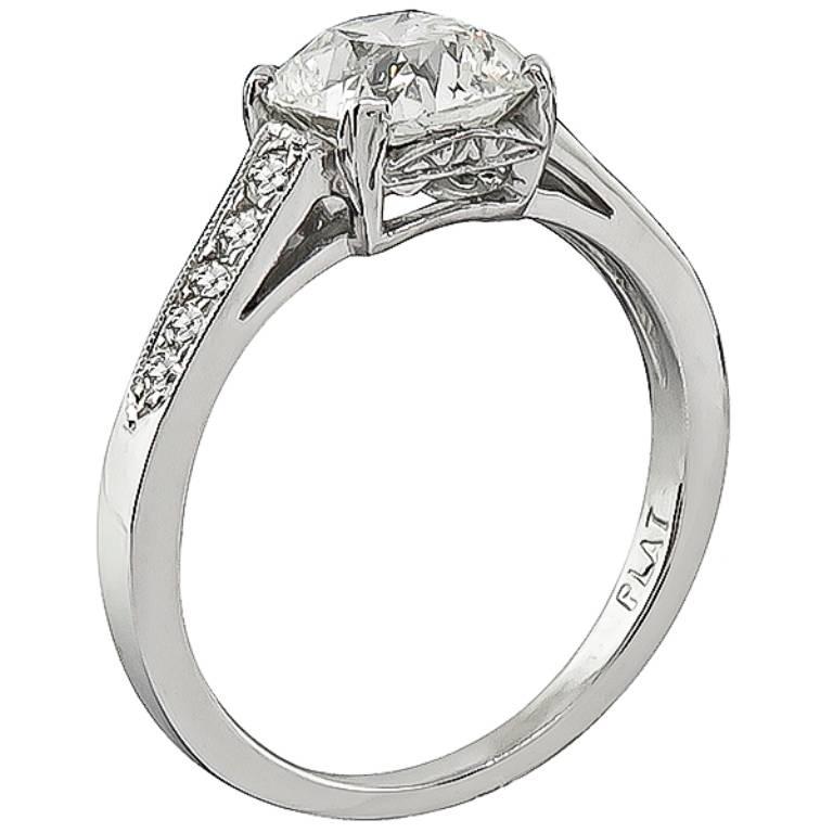 This stunning platinum engagement ring features a sparkling GIA certified cushion cut diamond that weighs 1.55ct. graded J color with VS2 clarity. The center diamond is accentuated by small round cut diamond accents. It is currently size 6, and can