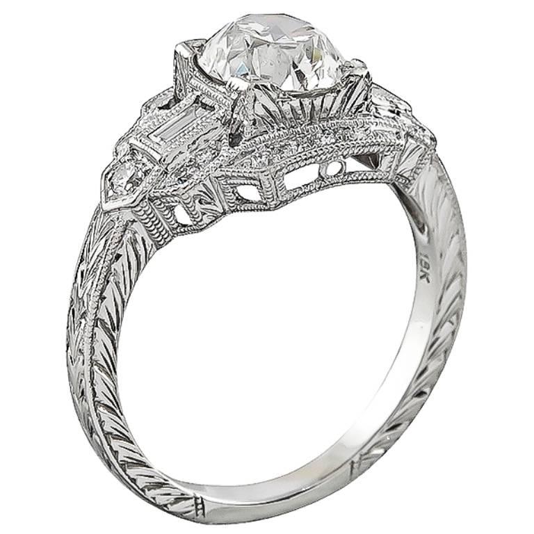 This stunning 18k white gold engagement ring from the Art Deco period, centers a sparkling GIA certified old mine cut diamond that weighs 1.17ct. graded H color with SI1 clarity. Accentuating the center stone are small round cut diamond accents. The