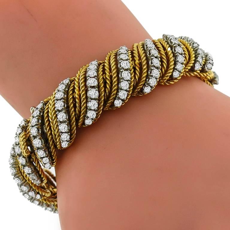 This elegant 18k yellow and white gold bracelet is set with sparkling round cut diamonds that weigh approximately 8.00ct. graded H color with VS clarity. The bracelet measures 13.5mm in width and 7 inches in length and weighs 69.2
