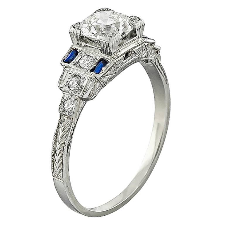 Made of 14k white gold, this ring is centered with a sparkling GIA certified old mine cut diamond that weighs 0.90ct. graded K color with SI2 clarity. The center diamond is accentuated by lovely sapphire and diamond accents. It is size 8 but it can