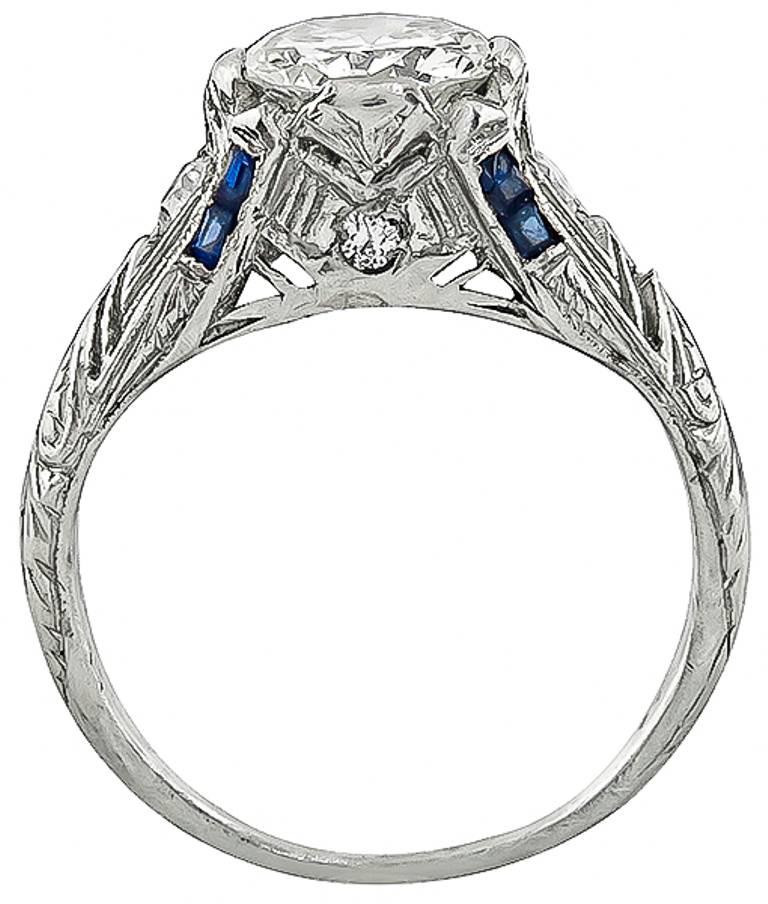 Handcrafted from the Art Deco era, this stunning  ring is centered with a sparkling GIA certified round brilliant cut diamond that weighs 1.08ct. graded J color with VS1 clarity. The center diamond is accentuated by high quality sapphire and diamond