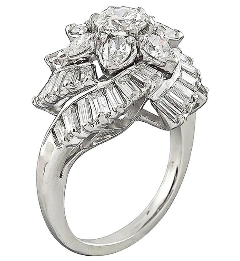 This amazing platinum ring is centered with a sparkling GIA certified round brilliant cut diamond that weighs 0.66ct. graded H color with VS1 clarity. Accentuating the center stone are dazzling pear and baguette cut diamonds that weigh approximately