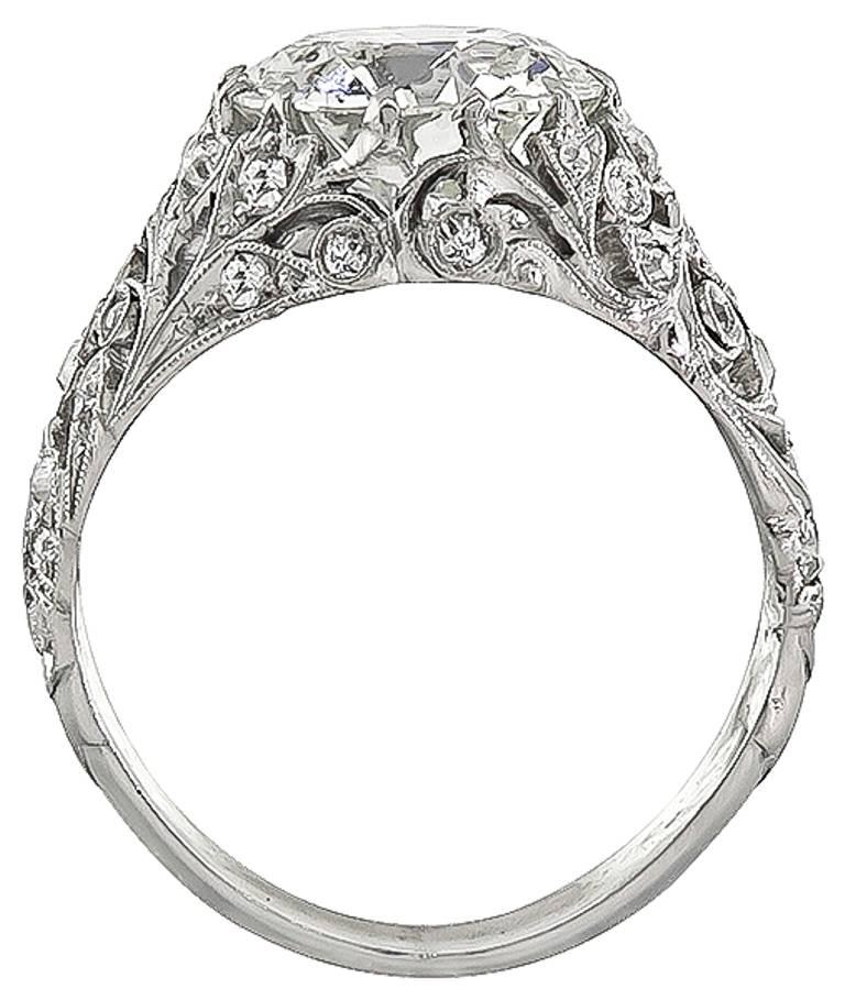 This is a stunning platinum engagement ring from the early 20th century, is centered with a sparkling GIA certified old European cut diamond that weighs 3.36ct. graded K color with SI2 clarity. Accentuating the center stone are high quality dazzling