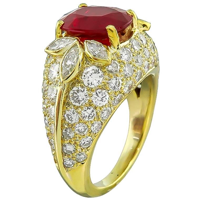Made of 18k yellow gold, this beautiful ring is centered with a high quality oval cut ruby that weighs 2.11ct. The ruby is accentuated by sparkling round and marquise cut diamonds that weigh weigh approximately 3.00ct. graded E-F color with VS