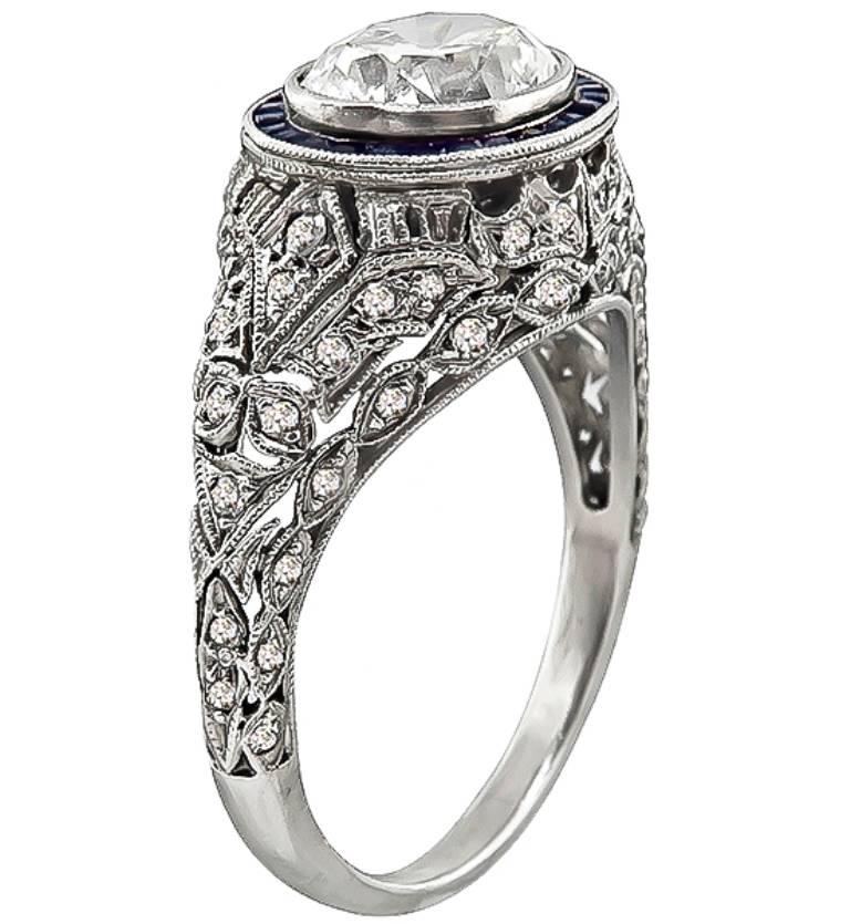 This magnificent platinum engagement ring from the Art Deco era, is centered with a sparkling cushion cut diamond that weighs approximately 1.50ct. graded G-H color with VS clarity. The center diamond is accentuated by sapphire and diamond accents.