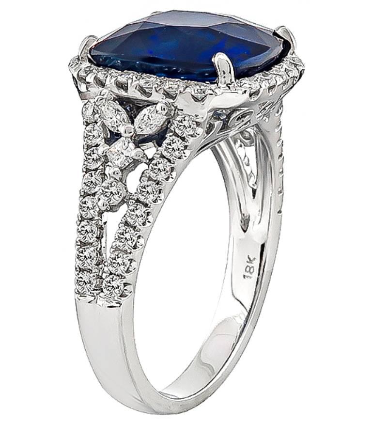 Made of 18k white gold, this ring is centered with a stunning cushion cut sapphire that weighs 6.85ct. Accentuating the sapphire are sparkling round and marquise cut diamonds that weigh approximately 0.50ct. graded H color with VS clarity. The top