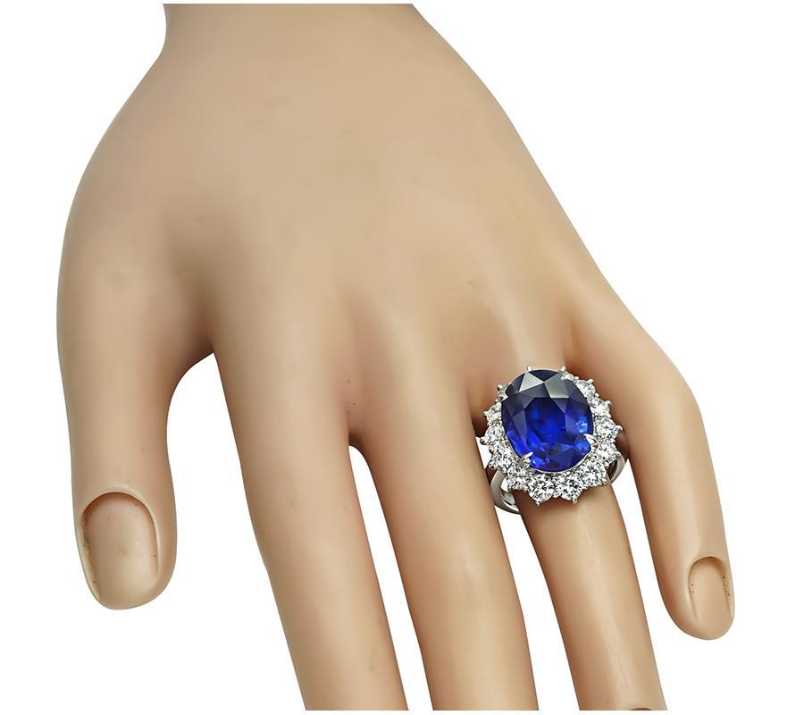 Se trata de un impresionante anillo de compromiso de platino. El anillo está centrado con un precioso zafiro de Ceilán de talla ovalada que pesa aproximadamente 15,05 ct. La piedra central está realzada por brillantes diamantes de talla redonda que