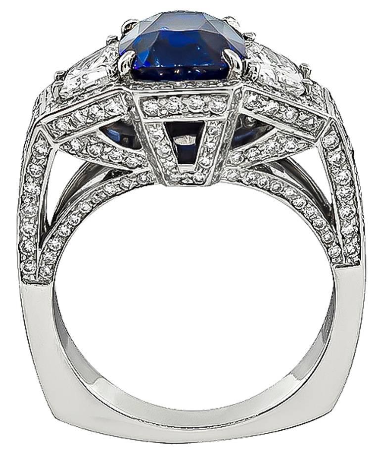 This impressive platinum ring is centered with an AGL certified cushion cut sapphire that weighs 3.93ct. The sapphire is accentuated by sparkling trapezoid and round cut diamonds that weigh approximately 2.50ct. graded G color with VS clarity. It is