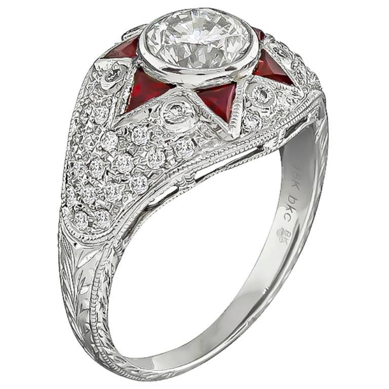 This amazing 18k white gold engagement ring is centered with a sparkling round cut diamond that weighs 1.01ct. graded I-J color with VS2 clarity. Accentuating the center stone are bright ruby accents and round cut diamonds weighing approximately