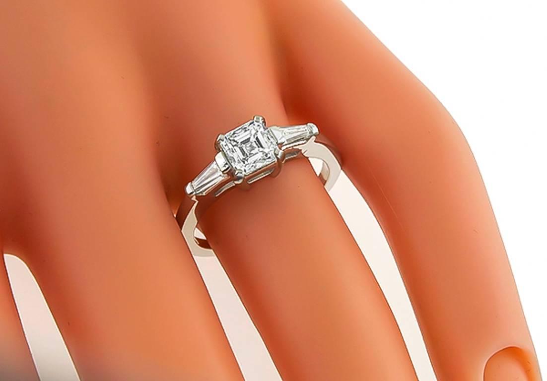 This fabulous 14k white gold engagement ring, is centered with a sparkling GIA certified asscher cut diamond that weighs 0.90ct. graded G color with VVS2 clarity. Accentuating the center stone are dazzling baguette cut diamond accents. The top of