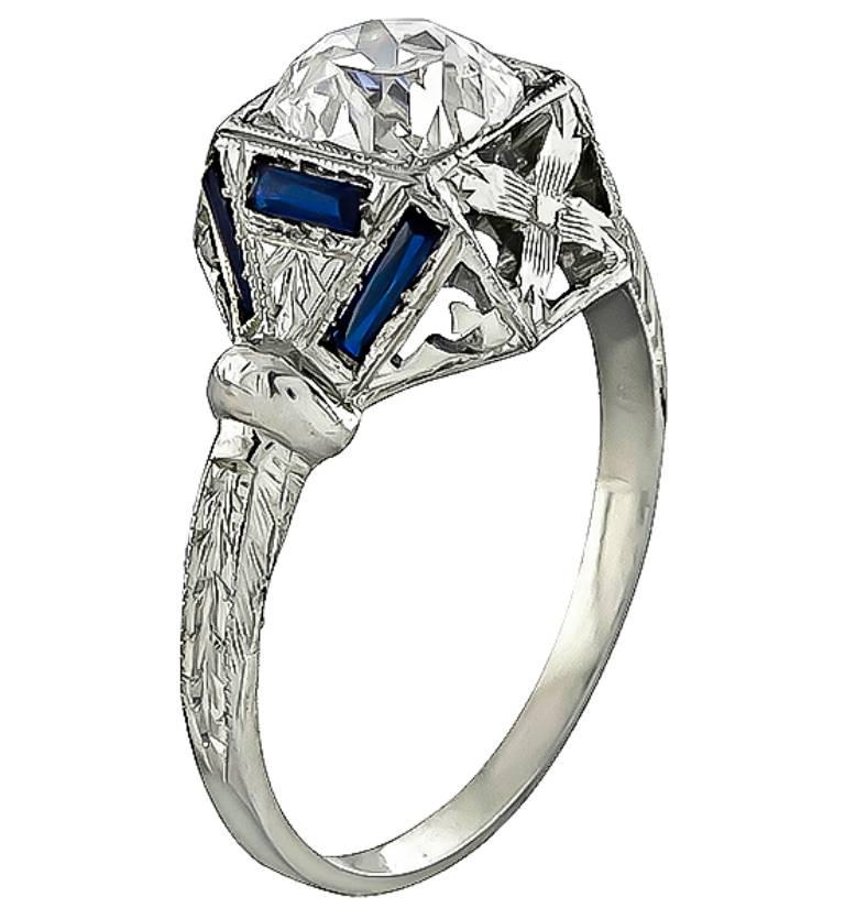 This amazing 14k gold engagement ring from the Art Deco era, is centered with a sparkling GIA certified old mine brilliant cut diamond that weighs 0.99ct. graded I color with VS1 clarity. Accentuating the center stone are stunning sapphire accents.