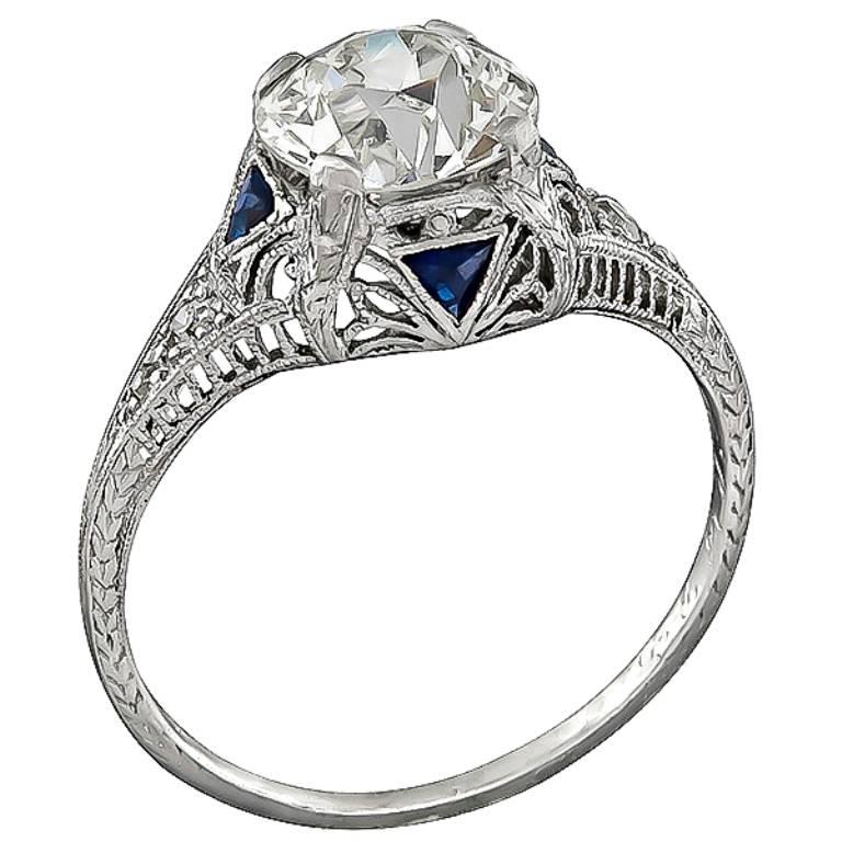 This beautiful platinum ring from the Art Deco era, is centered with a sparkling GIA certified old European cut diamond that weighs 1.95ct. graded J color with SI1 clarity. Accentuating the center stone are dazzling diamond and sapphire accents. The