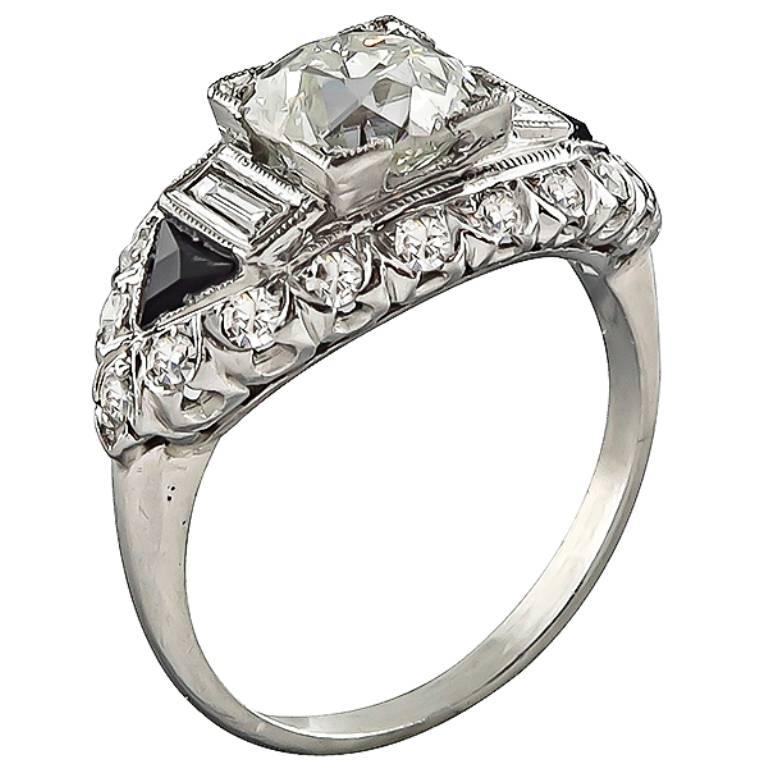 Handcrafted from the Art Deco era, this beautiful ring centers a sparkling GIA certified old European cut diamond that weighs 1.61ct. graded J color with I1 clarity. The center diamond is accentuated by diamond and onyx accents.
It is currently size