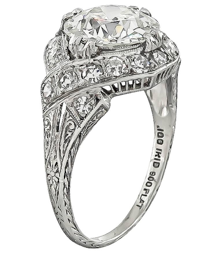 This stunning platinum ring from the Art Deco era, is centered with a sparkling GIA certified old European cut diamond that weighs 2.34ct. graded K color with VS2 clarity. Accentuating the center stone are dazzling round cut diamonds that weigh