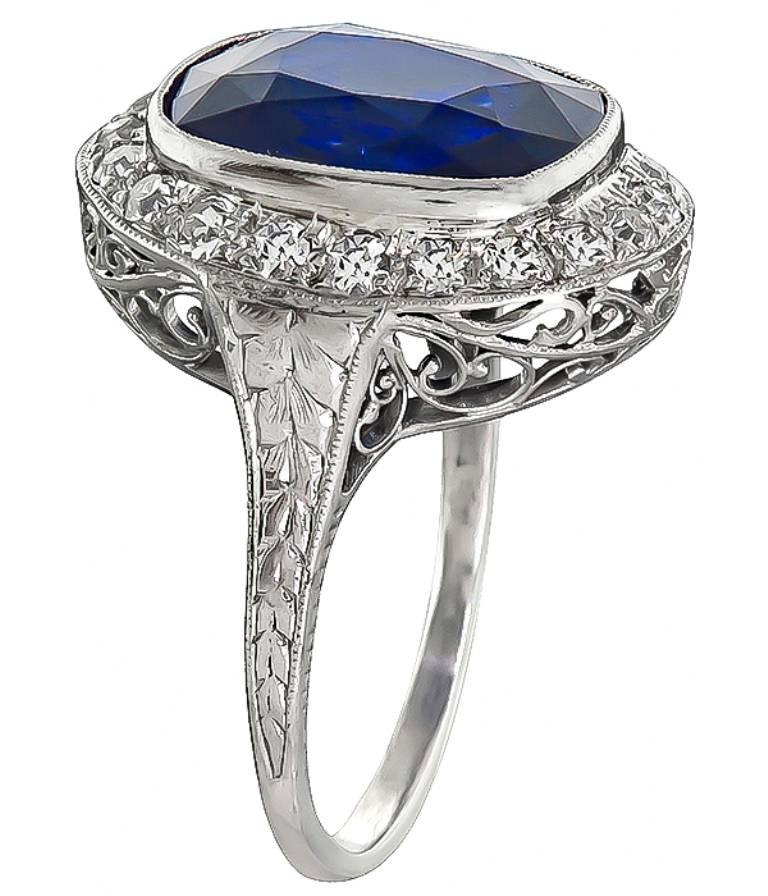 This gorgeous platinum engagement ring from the Art Deco era, is centered with a high quality even colored cushion cut sapphire that weighs 7.34 carats. Accentuating the sapphire are sparkling old mine cut diamonds that weigh approximately 0.80ct.