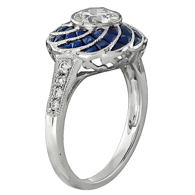 This amazing platinum engagement ring is centered with a sparkling GIA certified round cut diamond that weighs 0.91ct. graded H color with VVS2 clarity. The center diamond is accentuated by lovely sapphire and diamond accents.
It is currently size 6