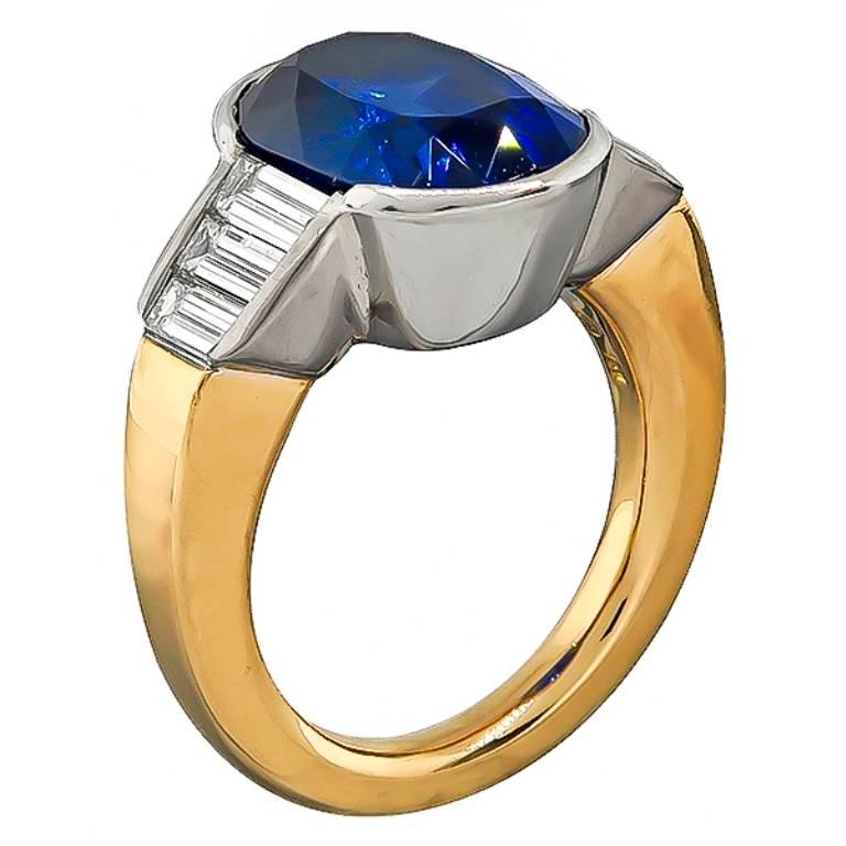 This stunning 18k gold ring features a lovely cushion cut GIA certified sapphire that weighs 7.71ct. with no indication of heating. Accentuating the center stone are sparkling baguette cut diamonds that weigh approximately 0.50ct. graded G color