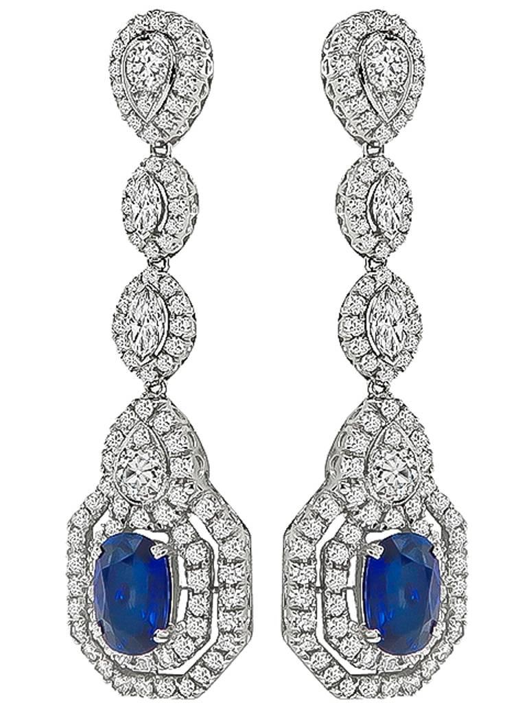 This fabulous pair of 18k white gold drop earrings feature cushion cut sapphires that weigh approximately 5.85ct. The sapphires are accentuated by sparkling marquise, old mine and round cut diamonds that weigh approximately 5.88ct. The color of