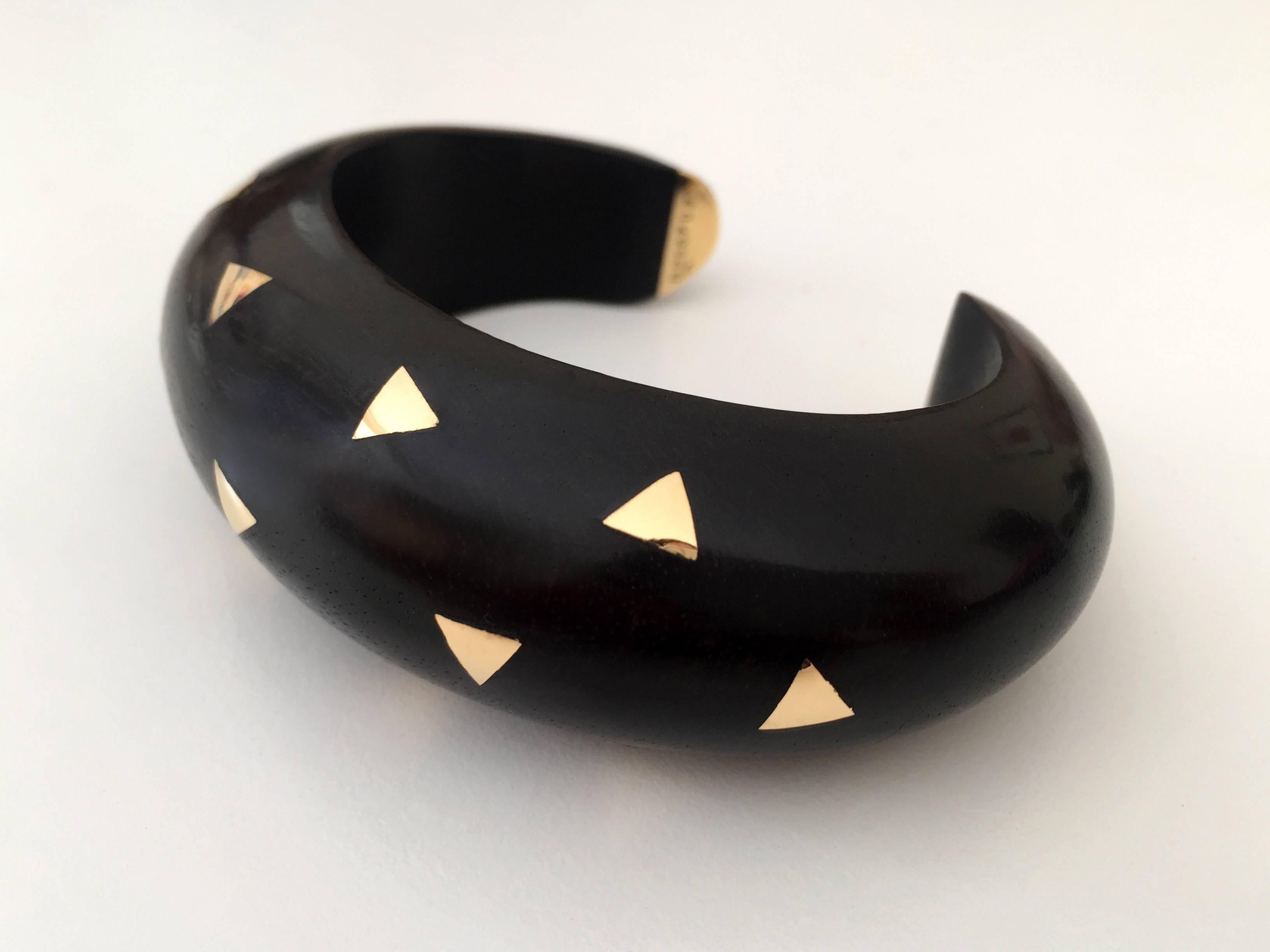 The Open Bangle bracelet from the 1980s is composed of carved ebony with inlayed 18 K gold triangles.
The Maison Van Cleef & Arpels, established in Place Vendôme since 1906,  has been designing iconic pieces for legendary clients.

Signed VCA and
