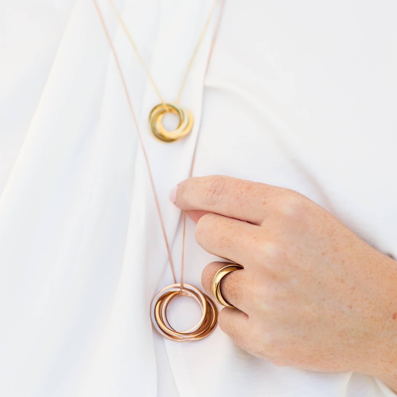 The diamonds in this russian ring necklace add luxury to the classic concept of family unity and togetherness, as represented by the interconnected three rings. Blending the three golds together - rose gold, white gold, yellow gold -
makes for a