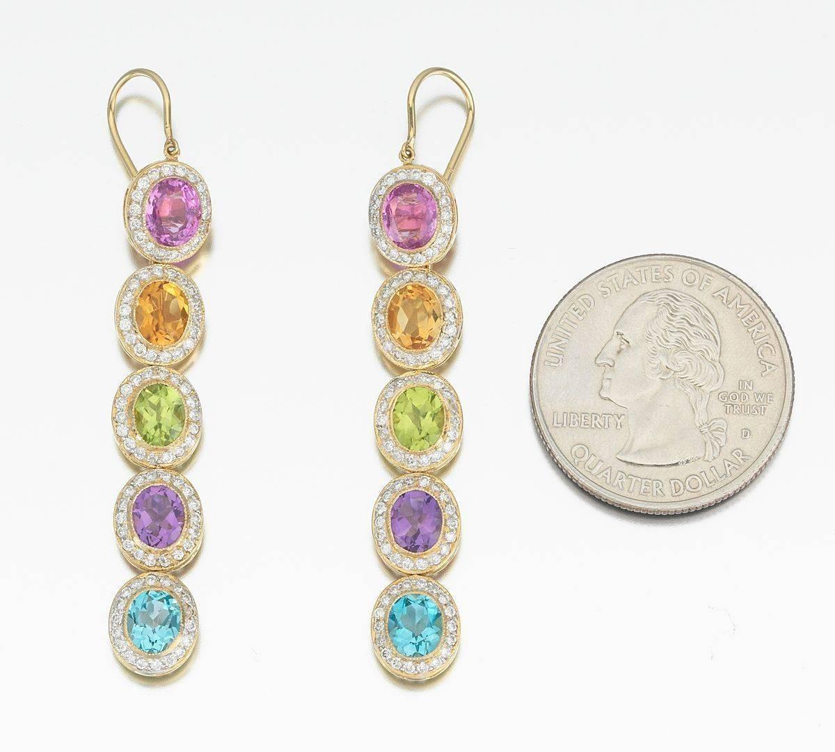 Striking and colorful jewelry set consisting of an 18k yellow gold pendant and earrings set with gemstones including: tourmaline, citrine, peridot, amethyst and topaz.  Each gemstone is 6mm x 8mm, all surrounded by a halo of brilliant cut diamonds. 