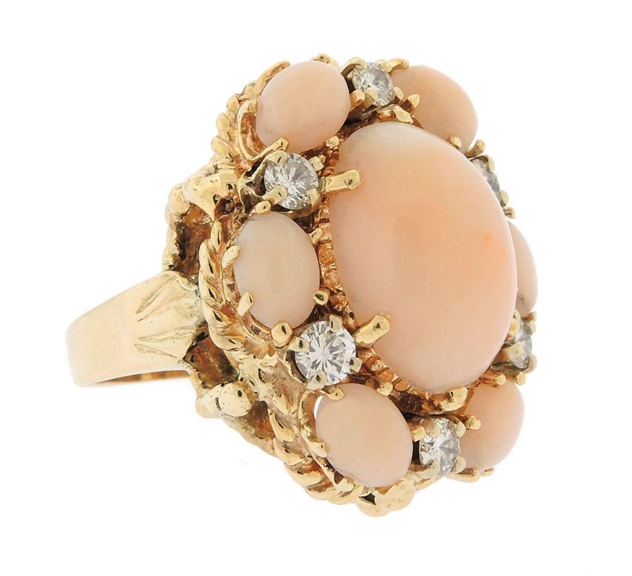Striking pale pink and peach angel skin coral statement ring.  A central angel skin coral cabochon is set with beautiful round-cut 0.50 carats of diamonds and a cabochon coral surround.  Lovely rope textured 14k gold on the high polish band.  The